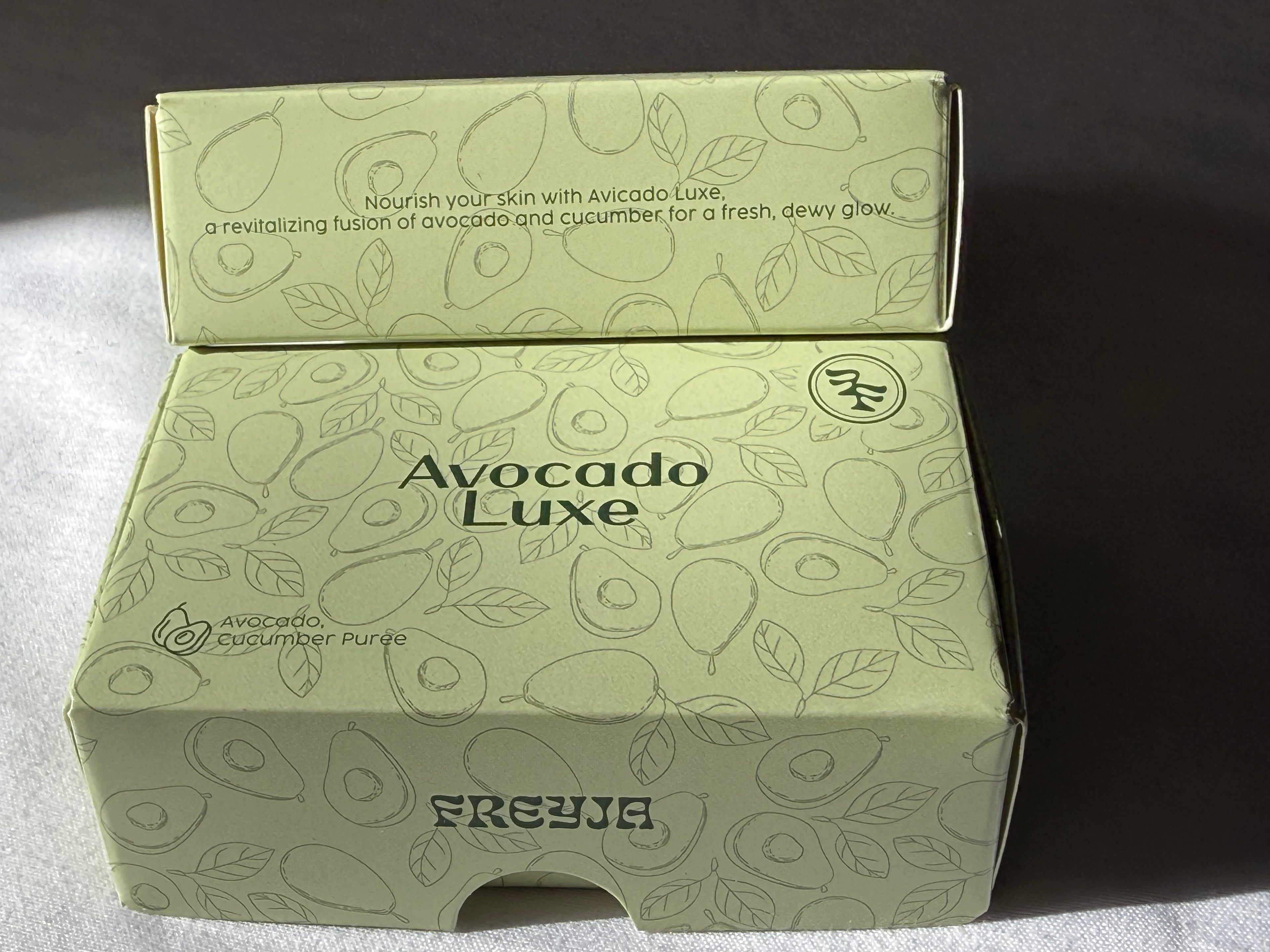 Avocado Luxe product packaging with avocado illustrations on a dark background