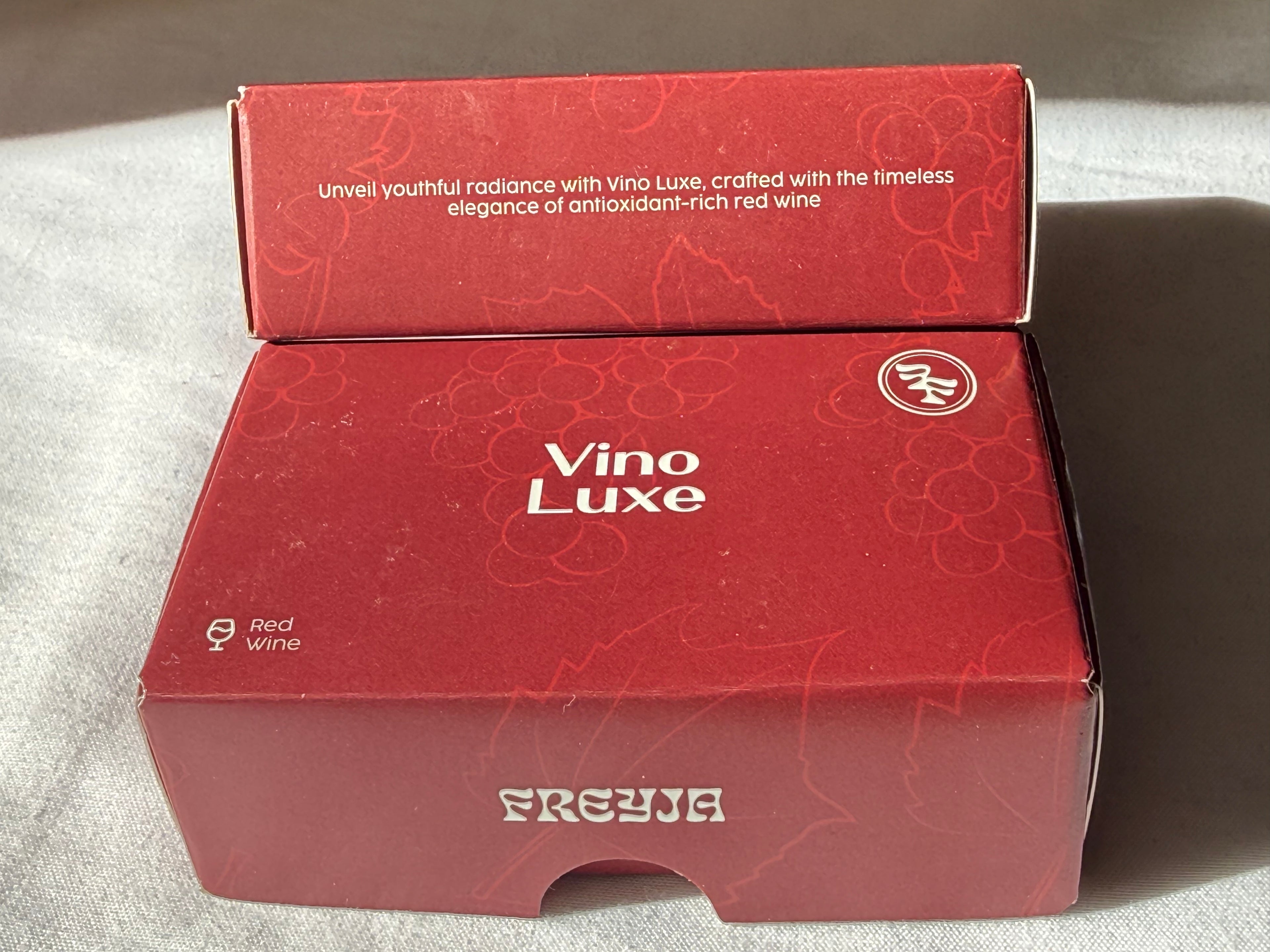 Red box with 'Vino Luxe' branding on a gray surface