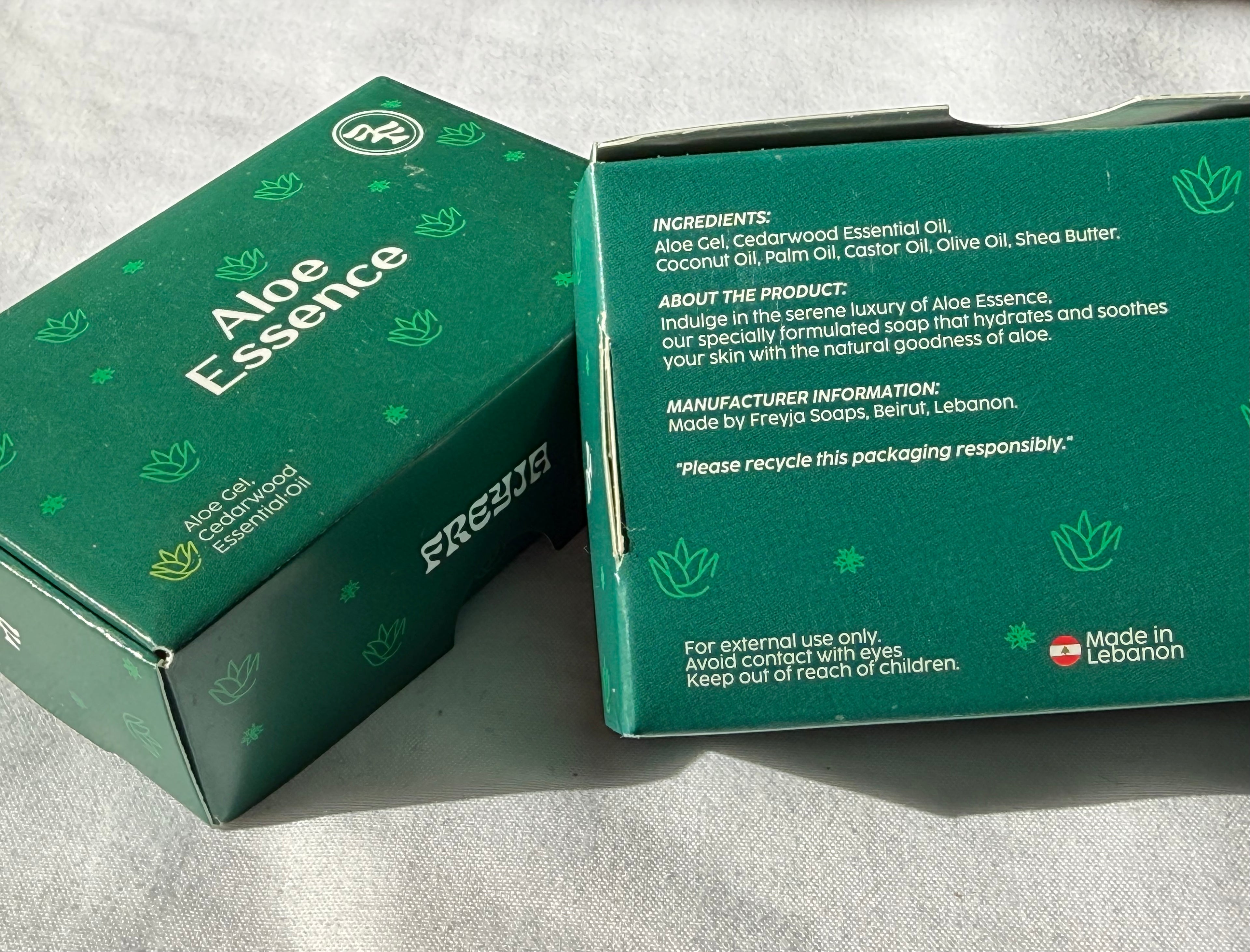 Green box of Aloe Essence soap with branding and product details.