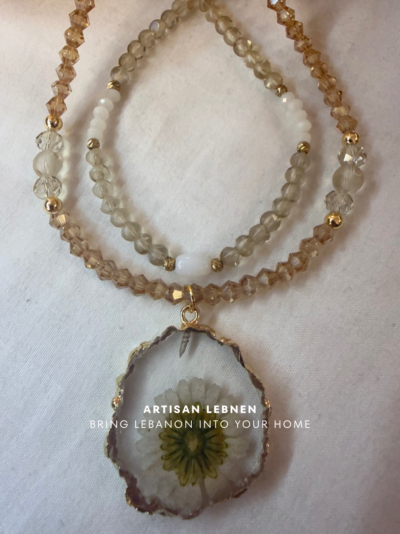 Necklace with agate pendant and beaded chain on a white background, featuring 'Artisan Lebnen' branding.