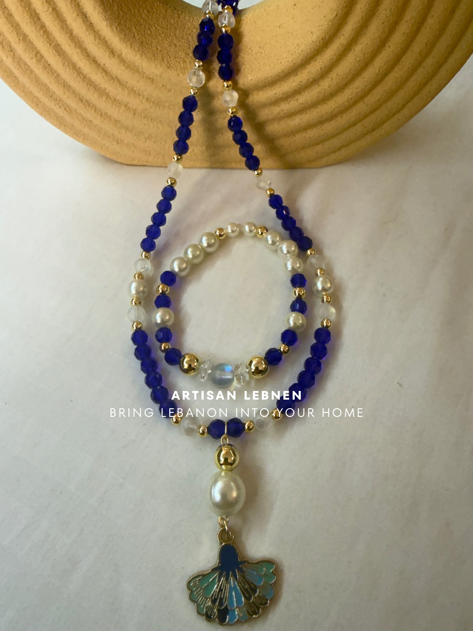 Beaded necklace with blue, white, and gold beads on a neutral background