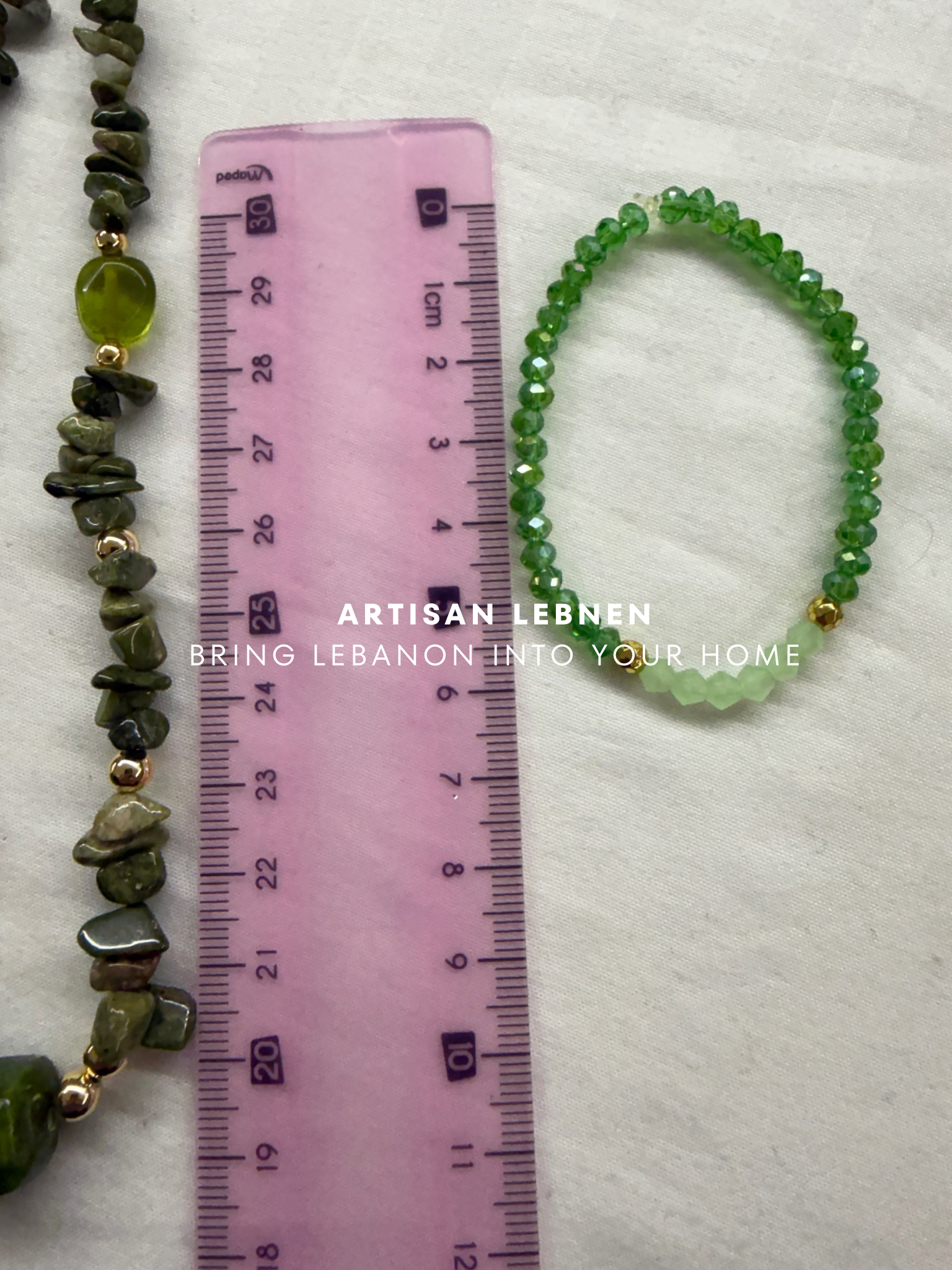 Green beaded necklace and bracelet with a ruler for size comparison on a white background, featuring 'Artisan Lebanon' branding.