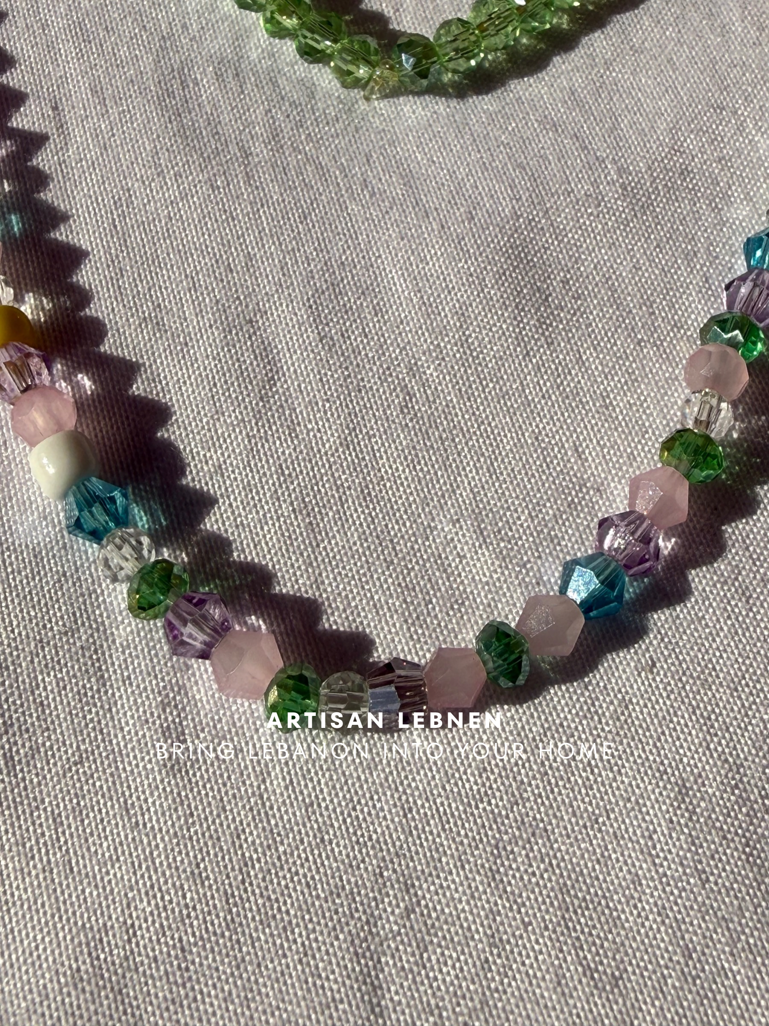 Necklace with multicolored beads on a textured fabric background